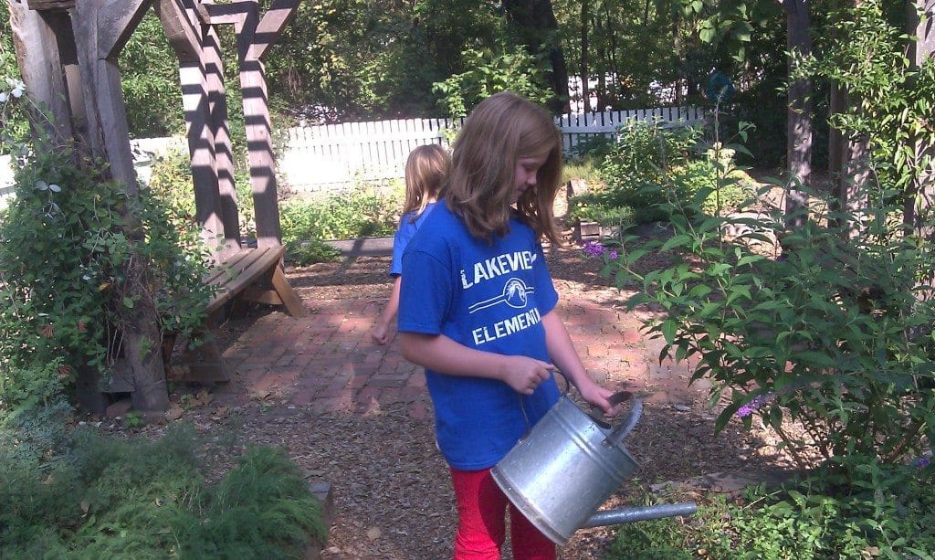 girl watering flowers at Travellers Rest Plantation and Museum garden
