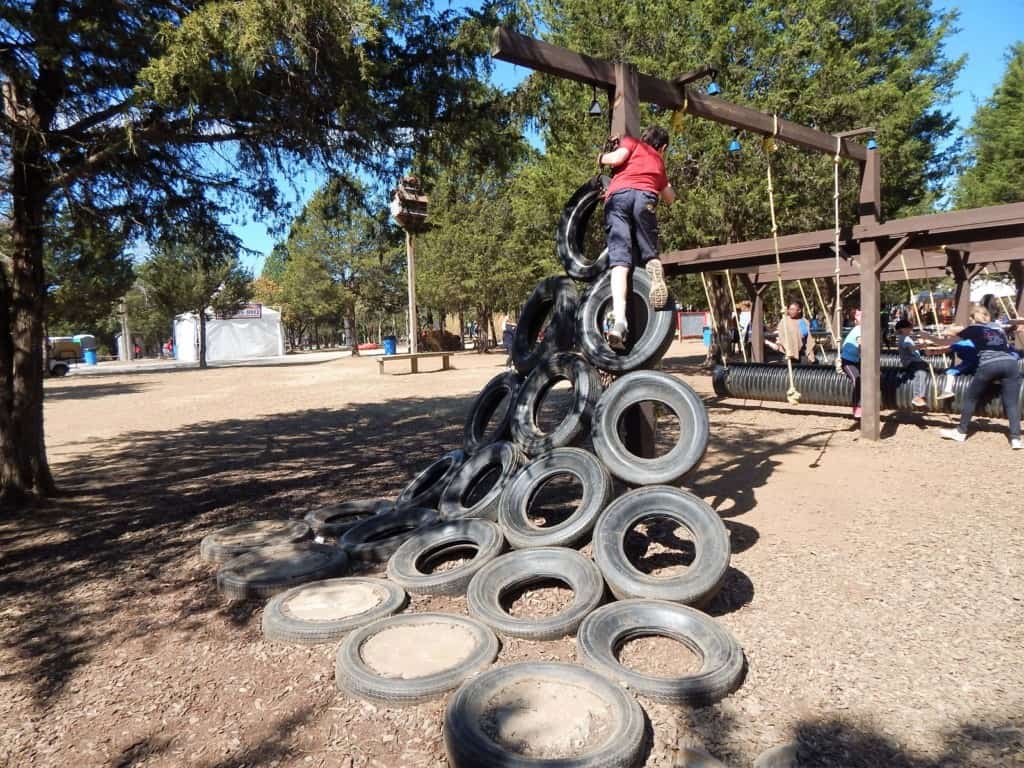 A boy climbing tires that create a ladder at Lucky Ladd Farms
