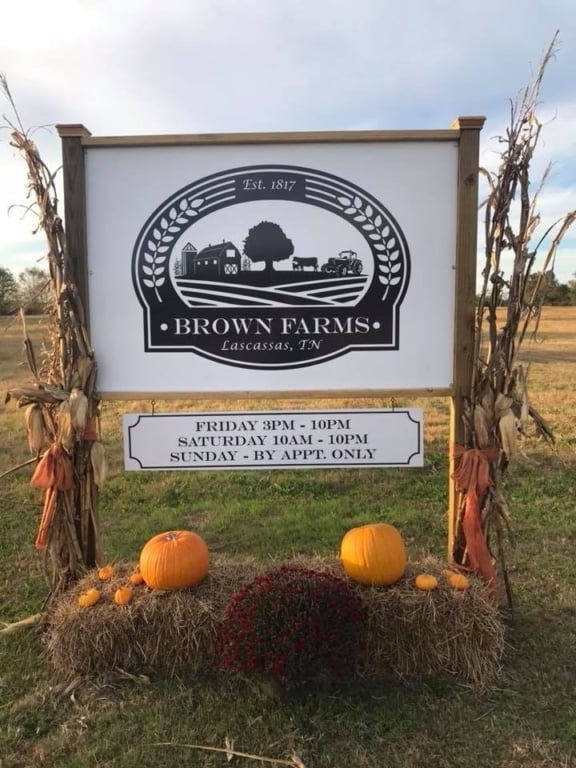 Brown Farms sign with corn stalks, pumpkins, and hay bails